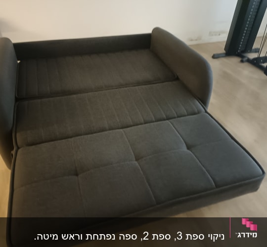 ספה נפתחת בצבע כהה על רצפת עץ